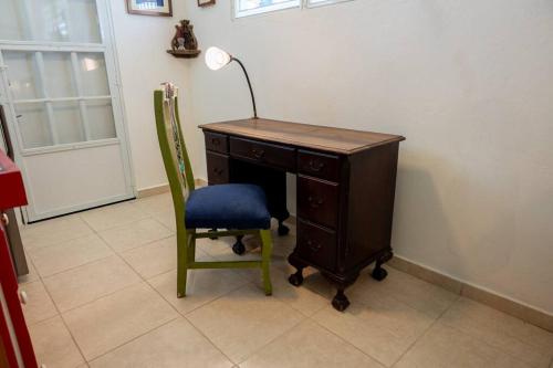 a desk with a lamp and a chair next to a door at Studio 1 Tinima with Garden access in Vieques