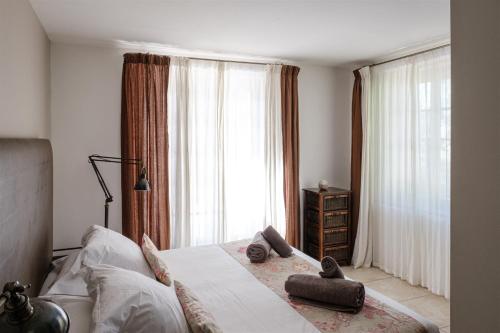 une chambre avec un lit et une grande fenêtre dans l'établissement Le Répertoire - Maison Capucine, à Pernes-les-Fontaines