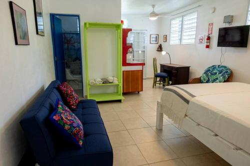 a bedroom with a bed and a couch and a desk at Studio 1 Tinima with Garden access in Vieques