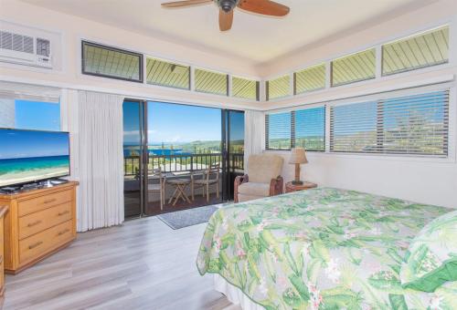 a bedroom with a bed and views of the ocean at 1623 Ridge in Kahana