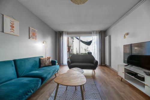 sala de estar con sofá azul y mesa en L'Eugène - Maison 3 chambres, en Vichy