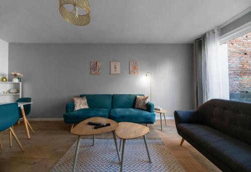 a living room with a blue couch and a table at L'Eugène - Maison 3 chambres in Vichy