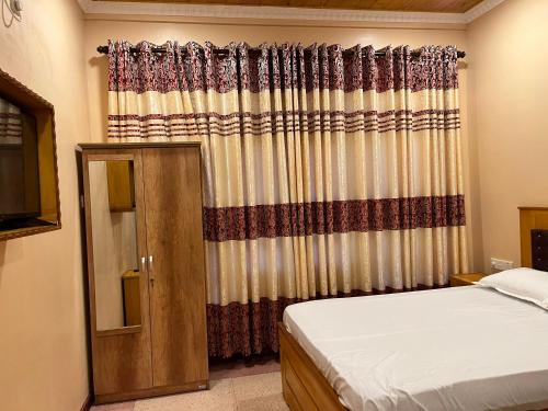 um quarto com uma cama e uma janela com uma cortina em Palm Path Resort em Jaffna