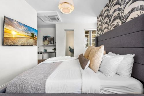 a bedroom with a white bed with a large headboard at Luxuri Suites 217 in Miami Beach in Miami Beach