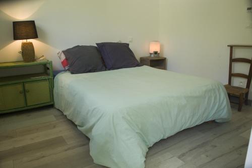 a bedroom with a large white bed with two pillows at maisonnette - quartier viarme in Nantes