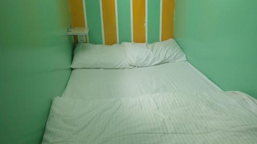 a bed with white sheets and pillows in a room at Ruby Star Hostel Dubai loft Beds G in Dubai