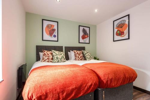 een slaapkamer met een groot bed met een oranje deken bij Smart 1 Bed Apartment in Central Hull in Hull