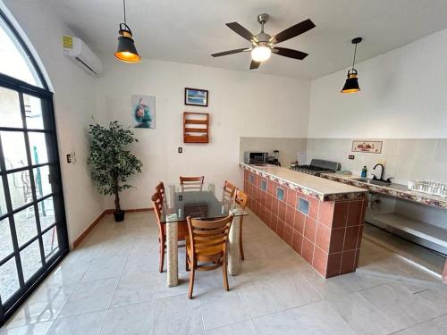 une cuisine avec une table et des chaises ainsi qu'un ventilateur de plafond dans l'établissement Casa Vacacional Playa del Carmen, à Playa del Carmen