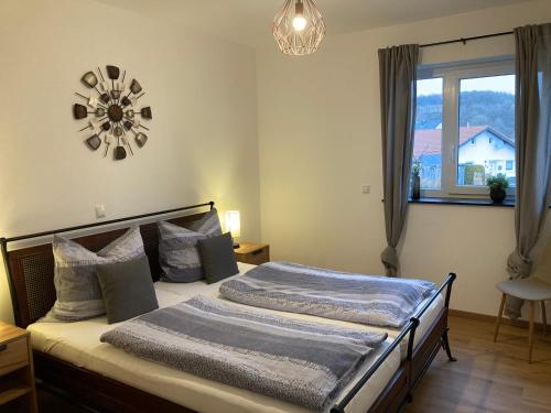 1 dormitorio con 1 cama con reloj en la pared en Ferienwohnung Am Hochkelberg, en Bereborn