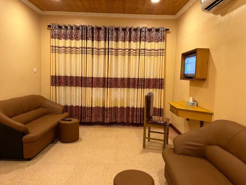 a living room with two couches and a desk at Palm Path Resort in Jaffna