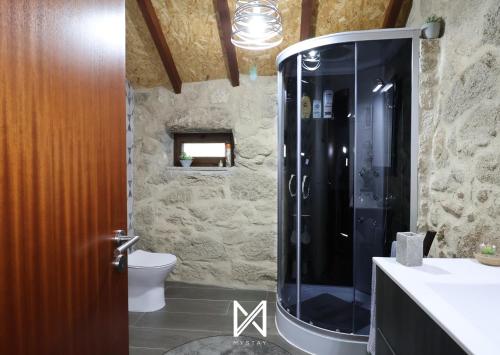 a bathroom with a shower with a toilet and a sink at MyStay - O Palheiro in Caramulo