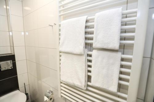 La salle de bains est pourvue de serviettes blanches suspendues à un porte-serviettes. dans l'établissement Sportschule Wedau, à Duisbourg