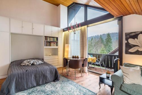 Schlafzimmer mit einem Bett, einem Tisch und einem Fenster in der Unterkunft Aixpress Apartment in Bad Herrenalb