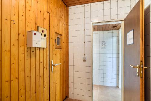 a bathroom with wooden walls and a shower and a door at Aixpress Apartment in Bad Herrenalb