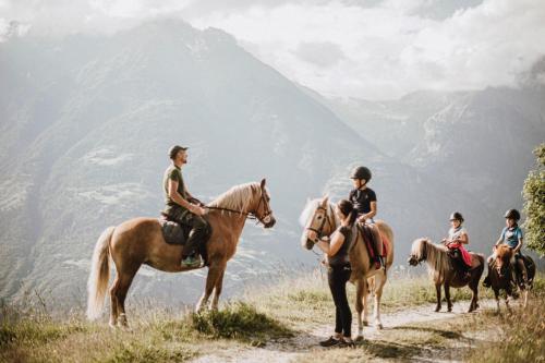un grupo de personas montando caballos en una colina en Tholer Ferienwohnung 2 en Lagundo