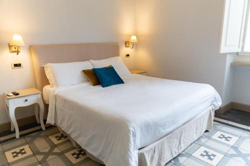 a bedroom with a large white bed with blue pillows at XX SETTEMBRE Urban Relais in Turin