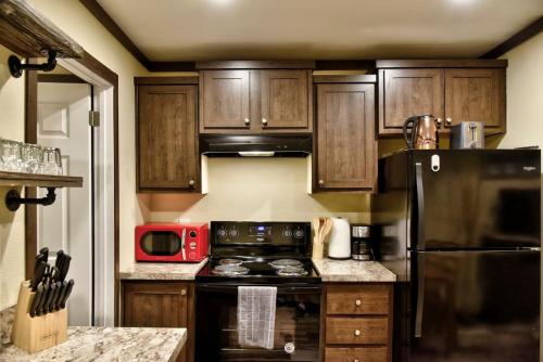a kitchen with a black stove and a red microwave at Lone Star Tiny Home - 15 minutes to downtown in Austin