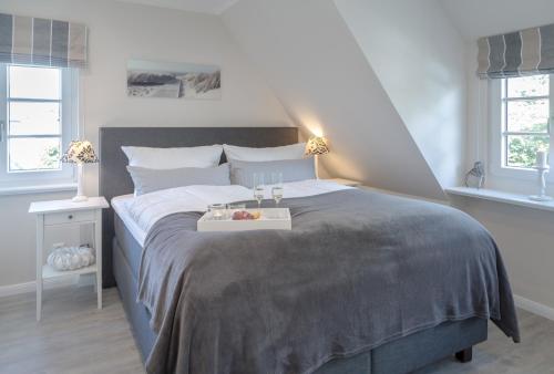 a bedroom with a bed with a tray of fruit on it at Hedigen Hüs in Westerland (Sylt)