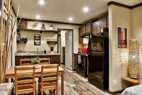 a kitchen with a table and a black refrigerator at Lone Star Tiny Home - 15 minutes to downtown in Austin