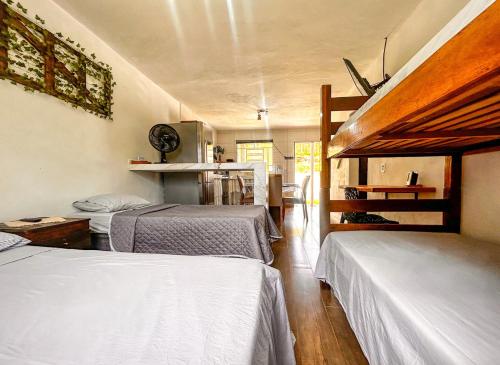 Habitación con 2 camas y cocina con en Casa confortavel com Wi-Fi em Braganca Paulista SP en Bragança Paulista