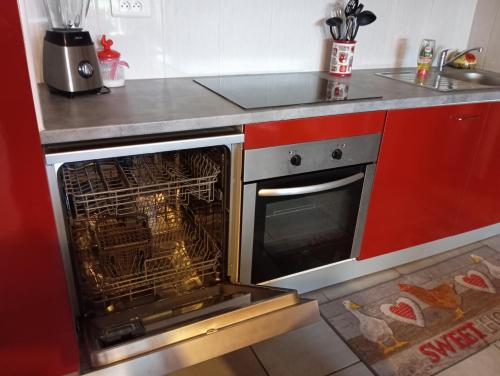a kitchen with an oven with a chicken in it at La petite maison dans la prairie in Notre-Dame-du-Touchet