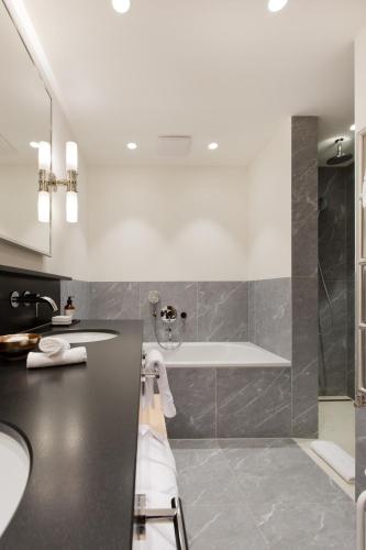 a bathroom with a tub and a sink at ANGELA Landhaus Fine Serviced Apartments and Double Rooms in Lech am Arlberg