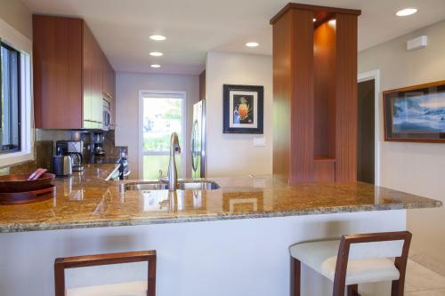 a kitchen with a counter with two bar stools at 1915 Ridge in Kahana