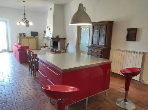 a kitchen with a red island with stools at Borgo Iris in Pietraia