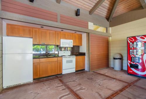 a kitchen with wooden cabinets and a white refrigerator at 1915 Ridge in Kahana
