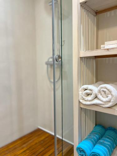 a shower stall with blue towels on a shelf at PortaDelMare deluxe suites in Hydra