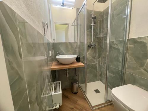 a bathroom with a sink and a glass shower at Monolocale Salvia Self check in in Pavia