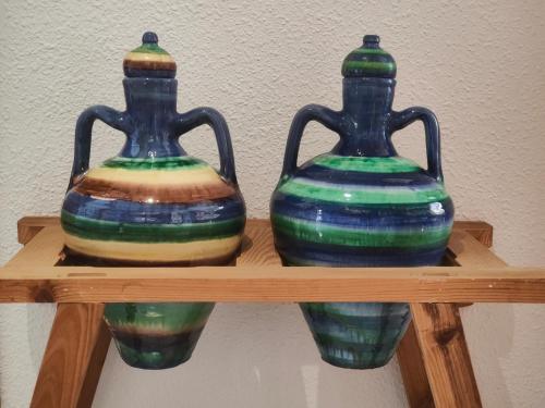 two vases are sitting on a wooden shelf at ENDAGORA in Níjar