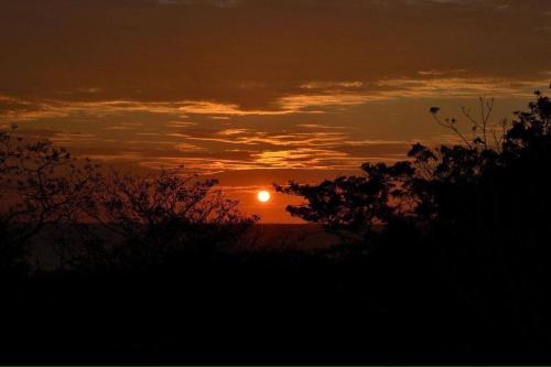 a sunset with the sun in the sky at El Castillo Divertido in Paraíso