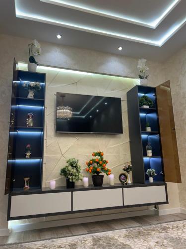 Apartment for tourists في سمرقند: مرآة كبيرة في غرفة بها الزهور والنباتات