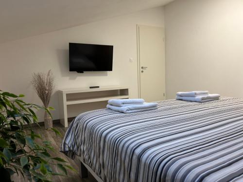 a bedroom with a bed with blue towels on it at Apartma Fojana in Dobrovo