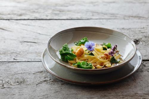 a bowl of pasta with a flower on a table at Medelina in Curaglia