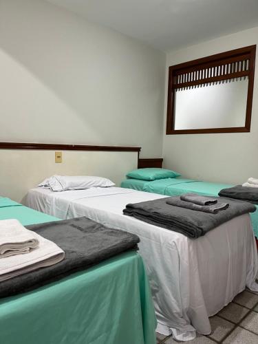 tre letti in una stanza con verde e bianco di Apartamento em frente a praia Costa 1001 a Vila Velha
