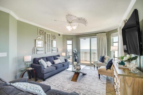 a living room with a blue couch and a tv at Gulfport Oceanfront Vacation Rental Walk to Beach in Gulfport