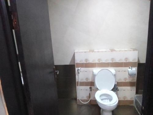 een badkamer met toilet met deksel bij Hotel bougainvillea Victoria island in Lagos