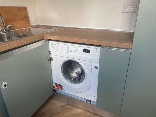a washing machine in a kitchen with a sink at Monolocale Salvia Self check in in Pavia
