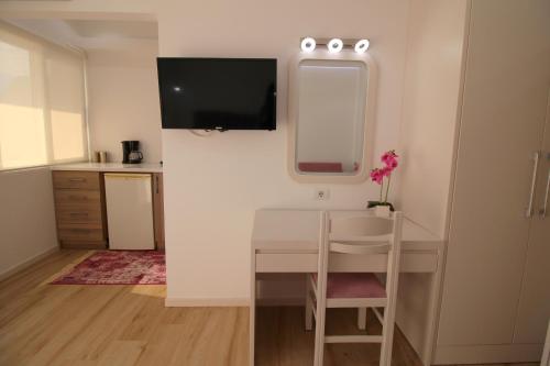 een kleine kamer met een bureau en een tv aan de muur bij Elena Hotel in Sarandë