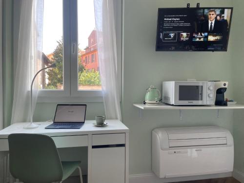 a laptop computer sitting on a desk next to a window at Monolocale Salvia Self check in in Pavia