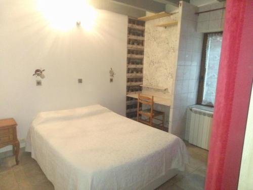 a bedroom with a white bed and a window at karine in Boucau