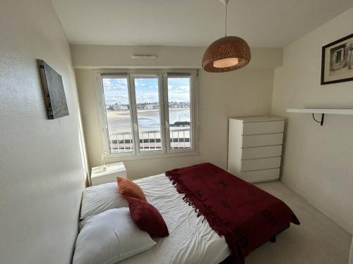 um quarto com uma cama e uma grande janela em 544 - Appartement T3 avec magnifique vue mer em Erquy