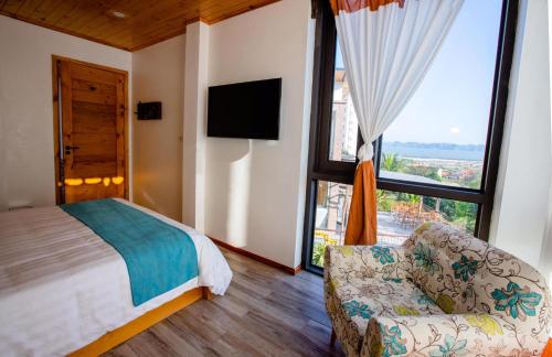 um quarto com uma cama, um sofá e uma janela grande em Homestay ECO MAY5 TRAVEL em Ha Long