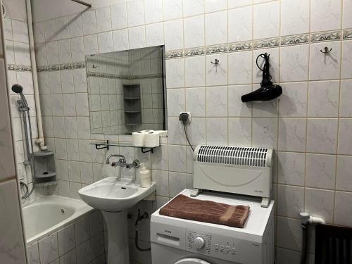 a bathroom with a sink and a washing machine at Florian 2 Apartment in Krakow