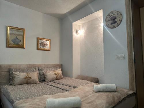 ein Schlafzimmer mit zwei Betten und einer Uhr an der Wand in der Unterkunft Apartment Sky in Visoko