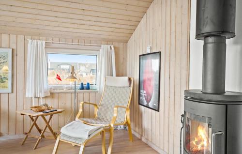 a living room with a chair and a fireplace at Amazing Home In Frøstrup With Sauna in Frøstrup