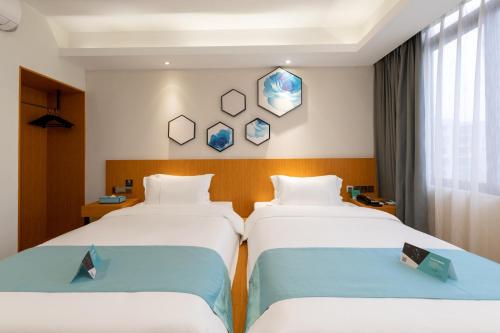 a hotel room with two beds and a window at Xana Lite Hotel - Guangzhou Fangcun Huadiwan Metro Station in Guangzhou