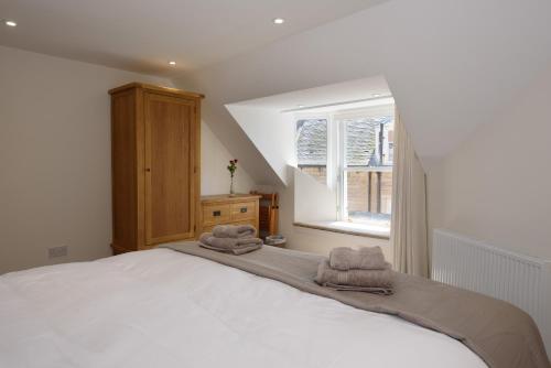 a bedroom with a bed with towels on it at Penthouse on the Harbour Pittenweem in Pittenweem